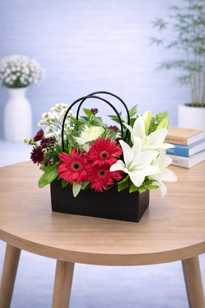 Black handbag flower base 14 - red gerbera and white lily arrangement in a matte black handbag box