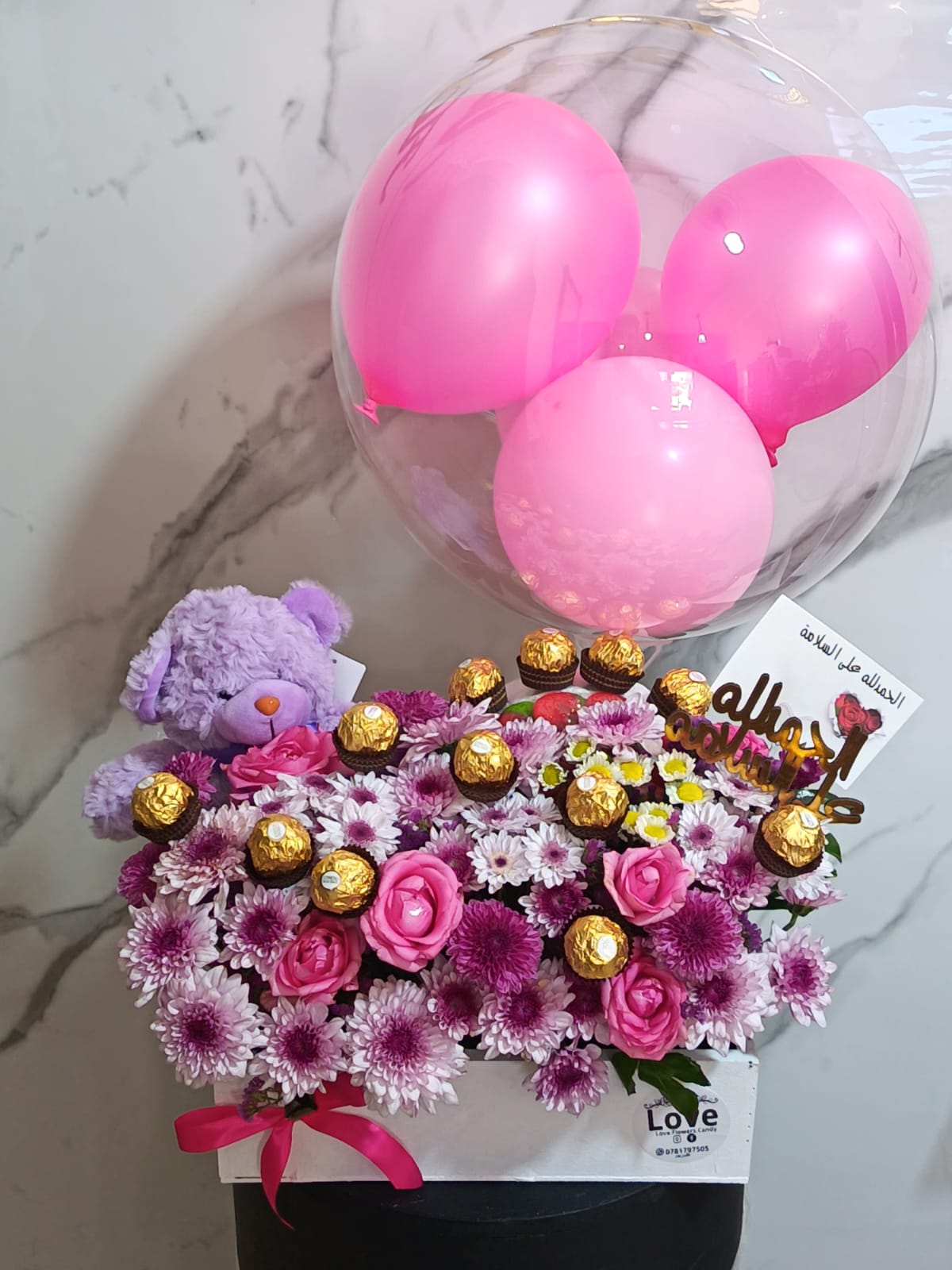Pink flower arrangement with balloons teddy bear and chocolates