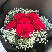 Red roses bouquet with baby's breath in matte black wrap