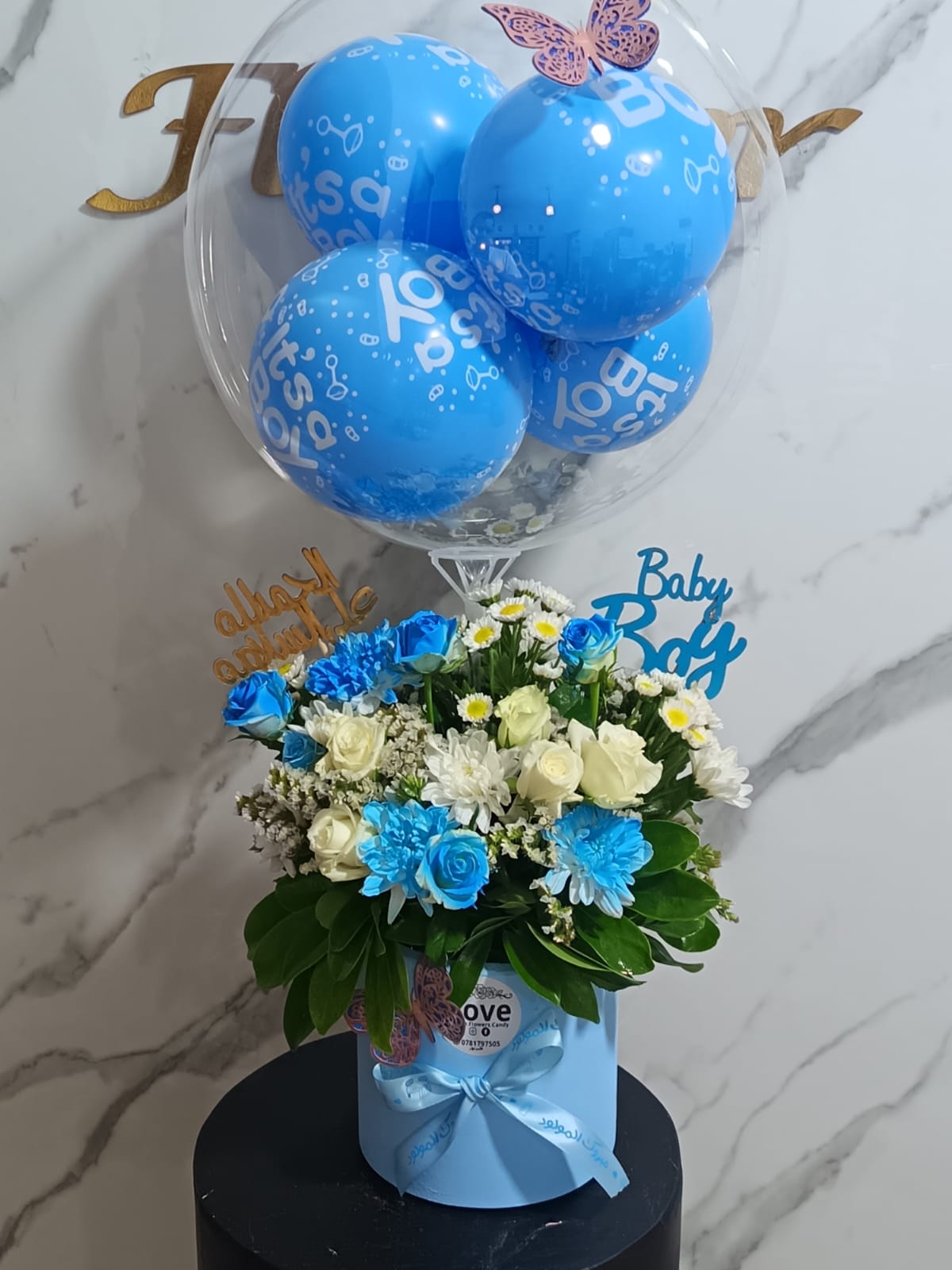Blue and white baby boy flower arrangement with balloons